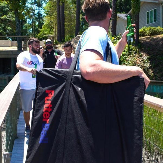 An image of a man carrying the PutterBall portable putting green in the travel bag.