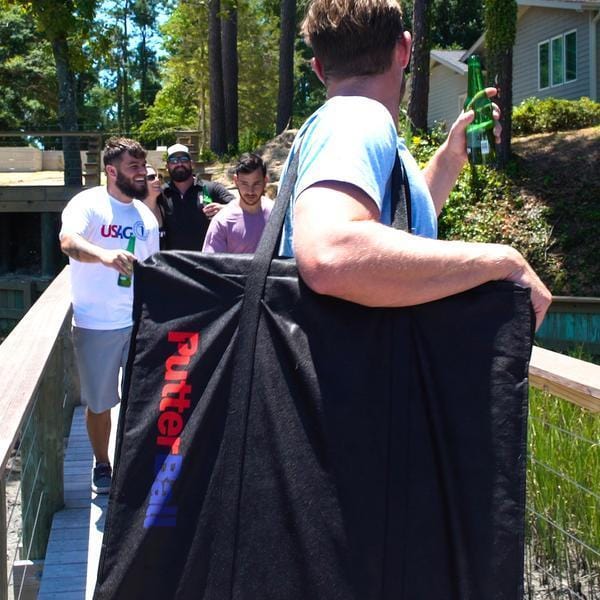 An image of a man carrying the PutterBall portable putting green in the travel bag.